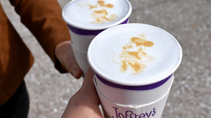 Guests hold out their Joffrey’s cups featuring Mickey and Minnie latte art within the foam of their hot beverages