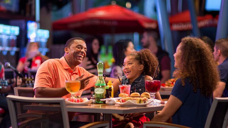 A father and mother and his young daughter enjoy food and beverages at the Splitsville Dining Room