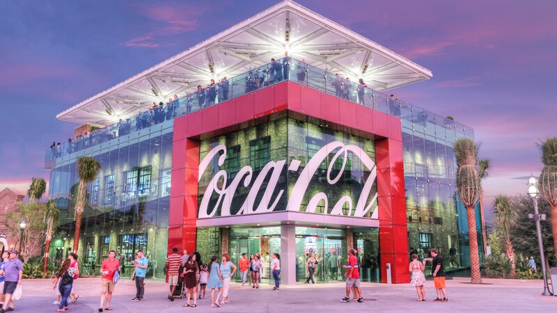 An artist rendering of the exterior of the Coca Cola Store with Guests enjoying the rooftop beverage bar