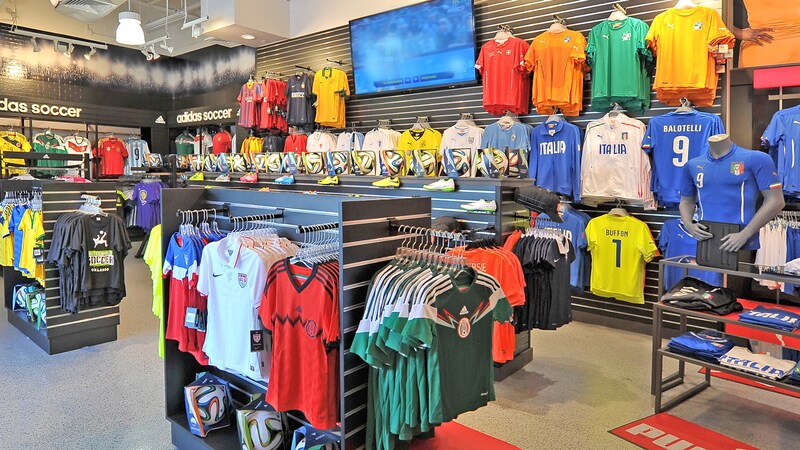Soccer jerseys hanging on display islands and on walls inside an apparel store