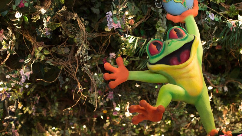 A large, smiling tree frog display welcomes Guests to the Rainforest Café
