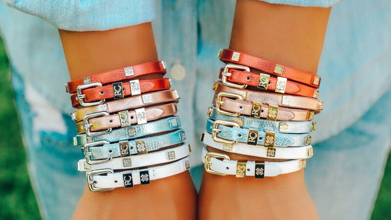 A variety of Rustic Cuff leather bracelets are displayed on a womans arms 