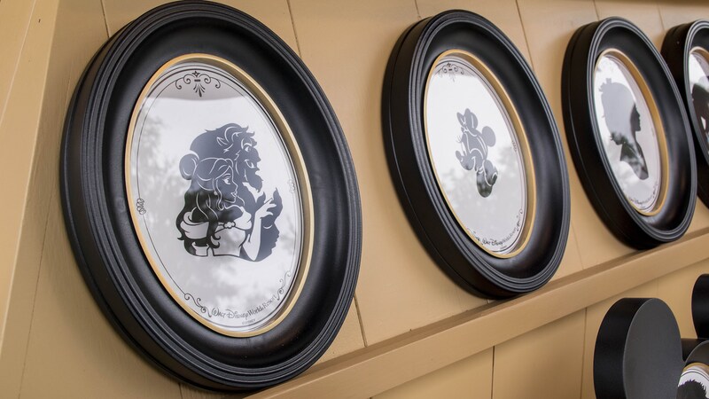 Framed portraits containing silhouettes of Minnie Mouse, Belle, the Beast and other Disney characters