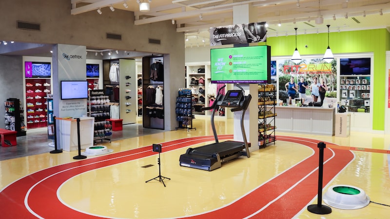 Interior of Fit2Run featuring a small indoor track, a treadmill and an area dedicated to an aetrex foot scanning device