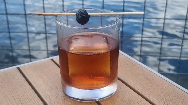 A baked Manhattan cocktail served in a glass and topped with a cherry