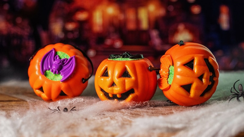 Three Halloween jack o lanterns sitting on top of spiderwebs