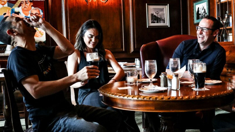 4 Guests sitting at a table while enjoying food and drinks at Raglan Road Irish Pub