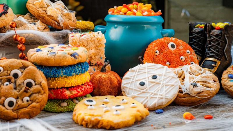 Stacks of Halloween themed cookies arranged on a table near fall decor