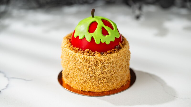 A cheesecake covered in graham cracker crust and topped with a caramel apple resembling a skull