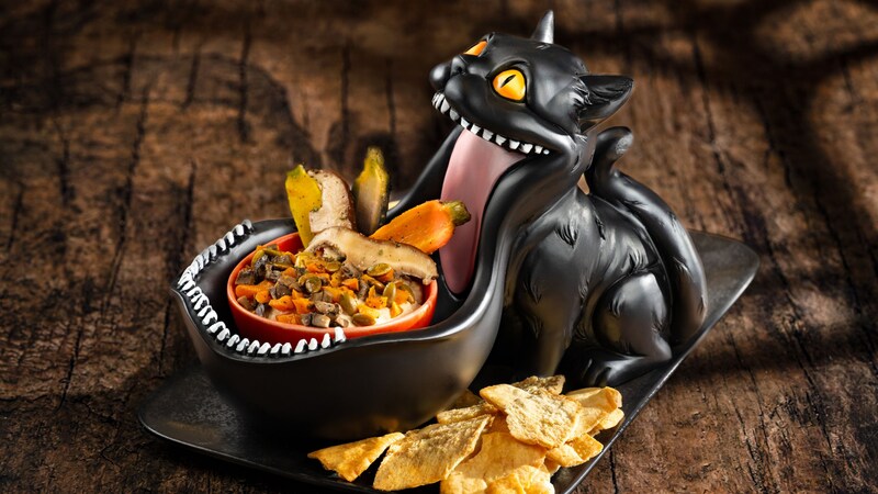 Dark Forest Dip served in bowl resembling the mouth of a cat, next to a pile of chips
