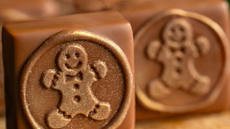 A wooden board with 2 Gingerbread Ganache Squares from The Ganachery	