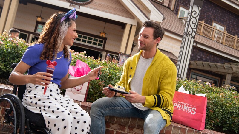 Two Guests enjoying a dessert and a beverage in front of Amorette’s Patisserie at Disney Springs