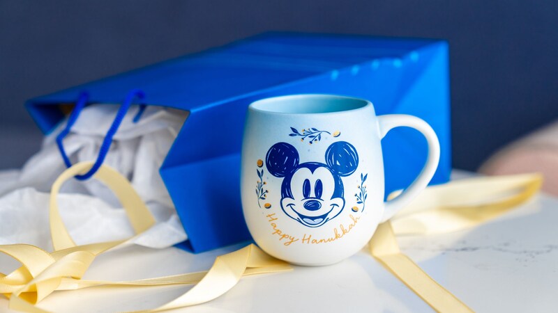 Una taza con la imagen de Mickey Mouse y la frase “Happy Hanukkah”