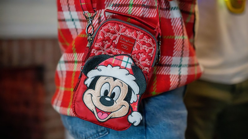 A Guest wearing a Santa Mickey Mouse crossbody bag