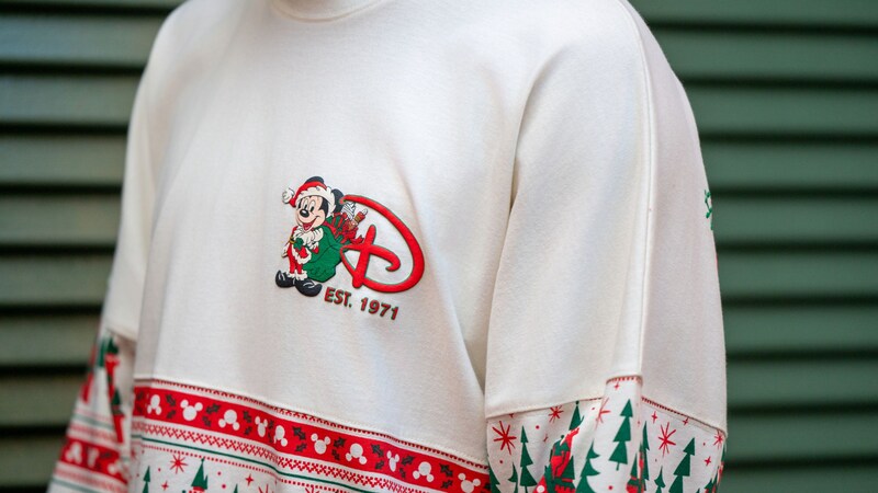 Un Visitante con una camisa de manga larga con temática navideña de Walt Disney World Resort