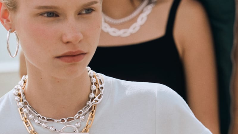 A woman wearing 3 distinct necklaces from the UNO de 50 retailer at Town Center in Disney Springs