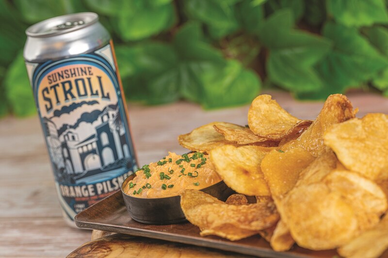 Orange Pilsner goat cheese dip, potato chips and a can of Orange Pilsner beer from Jock Lindsey’s Hangar Bar.