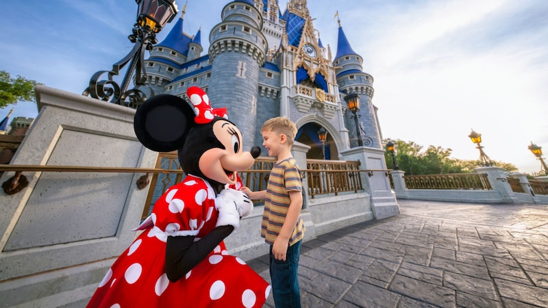 Minnie Mouse greeting a child in front of Cinderella Castle at Magic Kingdom park