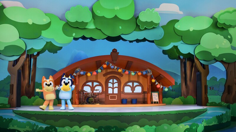 Bingo y Bluey posan en un escenario que simula una casa en el bosque en ¡El Mejor Día de Bluey!