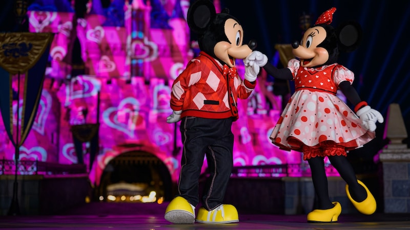 Mickey Mouse and Minnie Mouse dressed for Disney After Dark, Sweethearts Nite, in front of Sleeping Beauty Castle at Disneyland Park