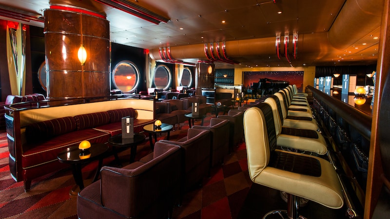 A woman and a man seated next to each other at a bar enjoy the cozy lounge atmosphere