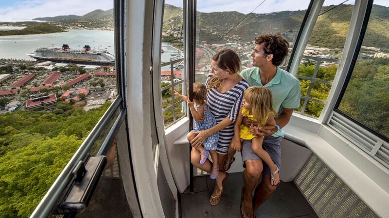 A young family of 4 ascending a mountain in a cable car