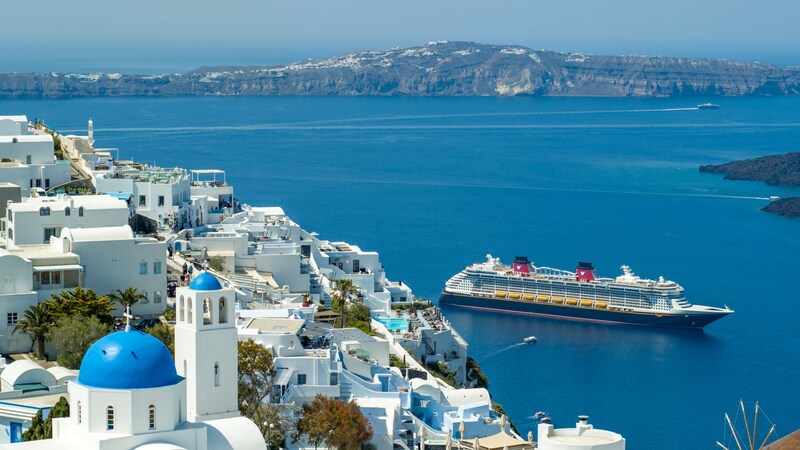 Seaside houses in Santorini, Greece with a Disney Cruise Line ship off the coast
