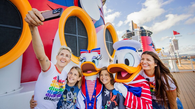 2 women and 2 children taking a selfie with Donald Duck and Daisy Duck