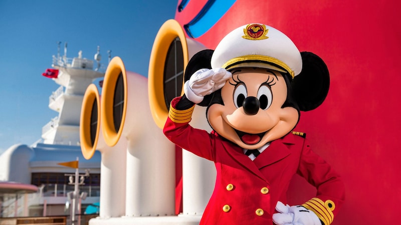 Captain Minnie Mouse wearing her regal captain’s uniform salutes the camera aboard the Disney Wish vessel