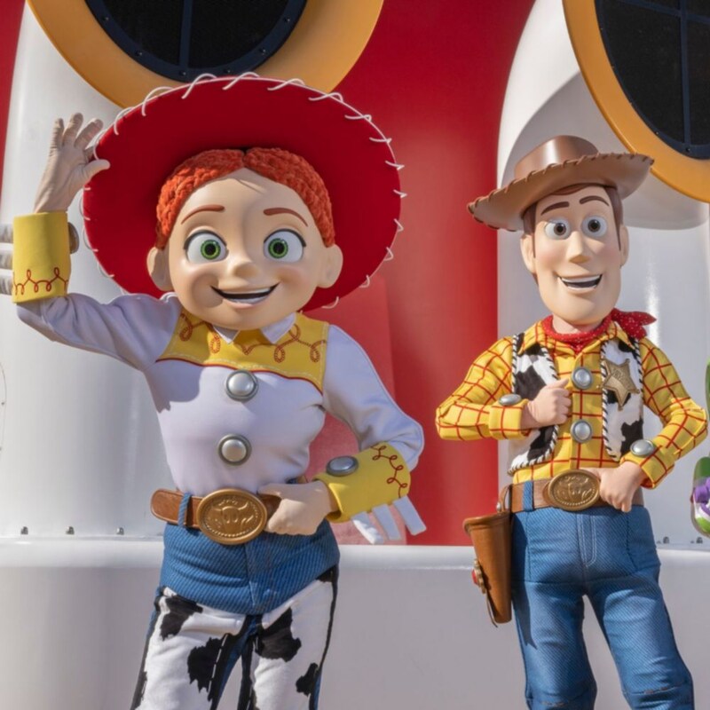 Jessie and Woody from the Toy Story movies standing by the funnels of a Disney cruise ship