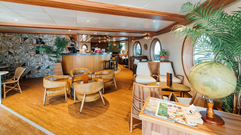 A bar, tables and chairs inside the Cove Café on board the Disney Wonder cruise ship