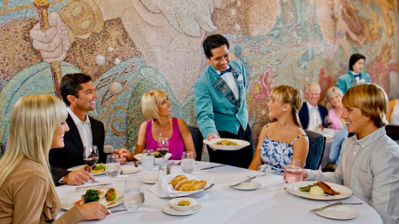 The elegant interior of Triton’s restaurant reveals an ocean theme with a mural of Triton and a series of dining tables set with linen table clothes