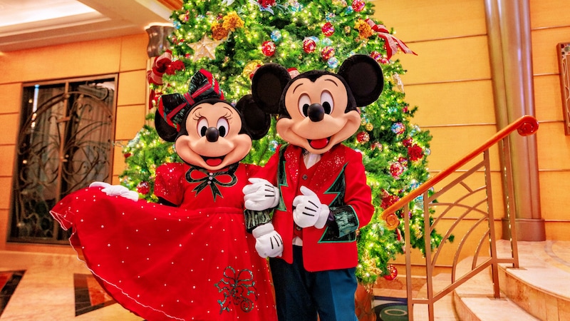 Minnie Mouse and Mickey Mouse wearing Christmas outfits and standing in front of a Christmas tree in the Disney Wonder atrium Minnie Mouse and Mickey Mouse wearing Christmas outfits and standing in front of a Christmas tree in the Disney Wonder atrium