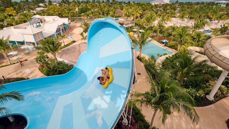 A family rafting down a water slide at Baha Bay