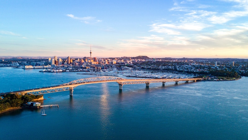 A long bridge spanning across a harbor to a cosmopolitan city
