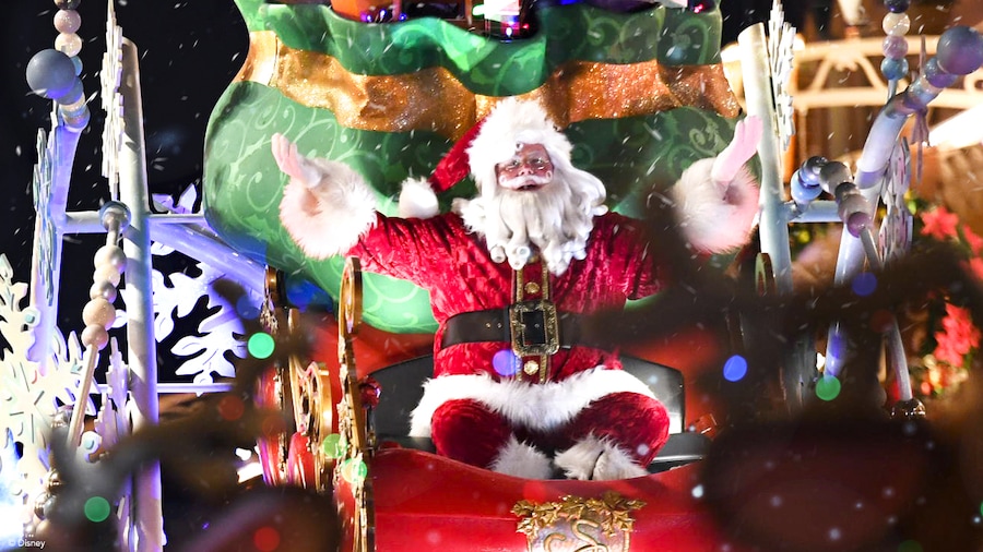 Santa Claus waves to guests while riding a holiday float down Main Street U.S.A.
