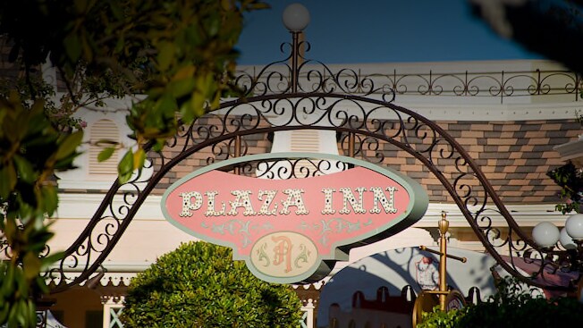 An archway with a sign saying 'Plaza Inn'