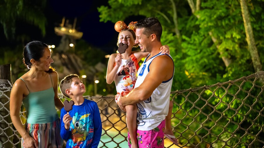 Two young Guests with their parents eating Mickey Mouse shaped ice cream bars during Disney H2O Glow After Hours at Disney’s Typhoon Lagoon water park