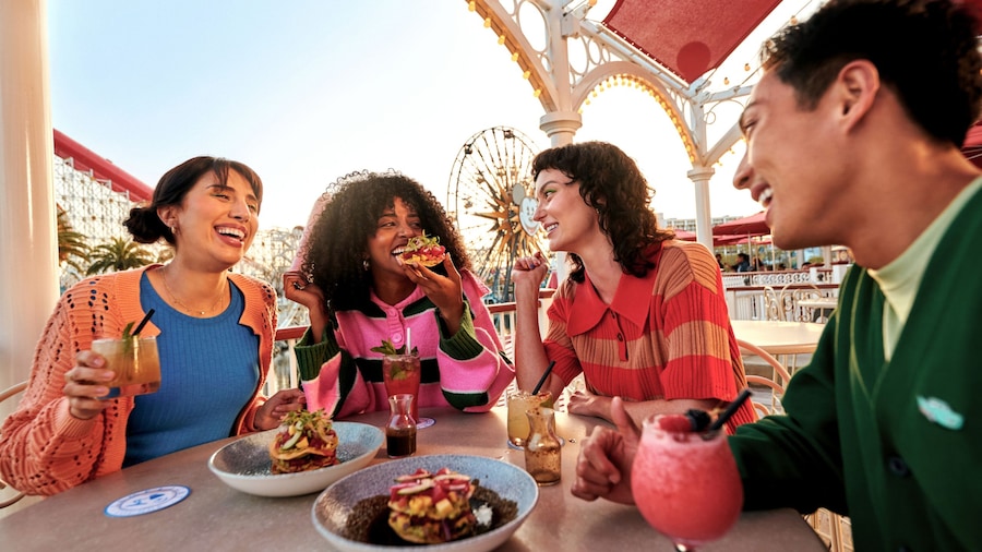 A group of 4 friends enjoying food and drinks at the Lamplight Lounge
