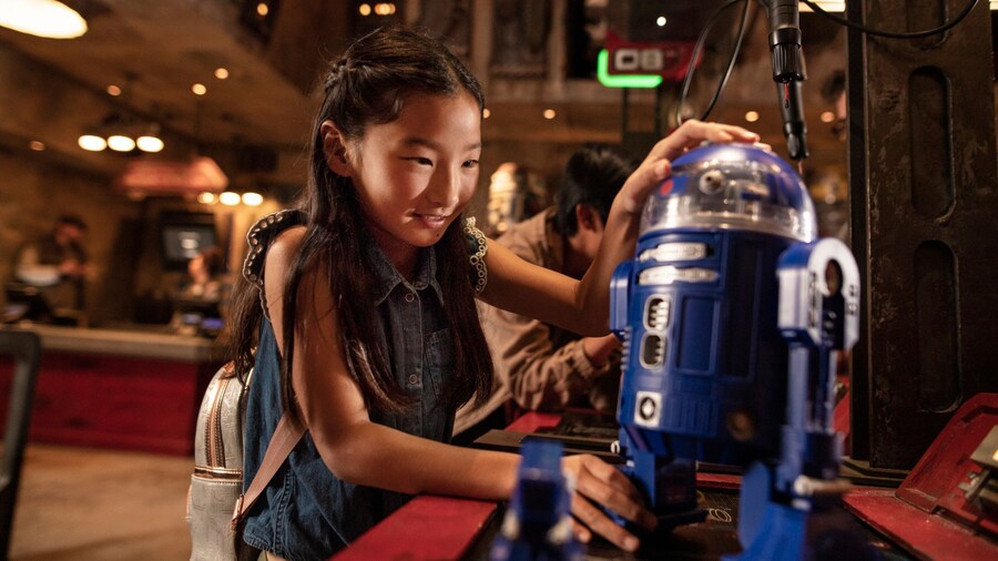 A young girl assembling an astromech droid at Droid Depot