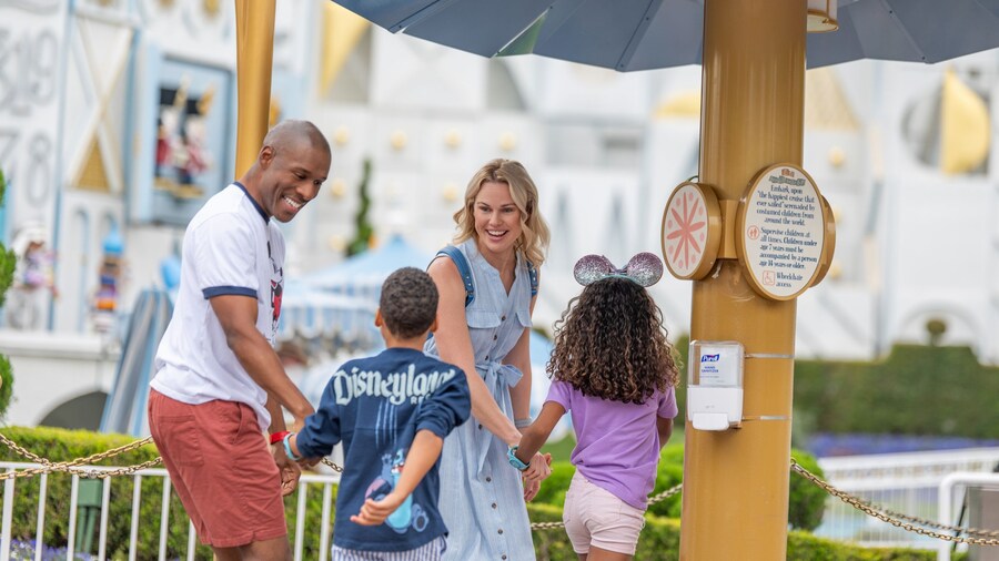 A family of 4 outside the Lightning Lane entrance for ‘it’s a small world’	