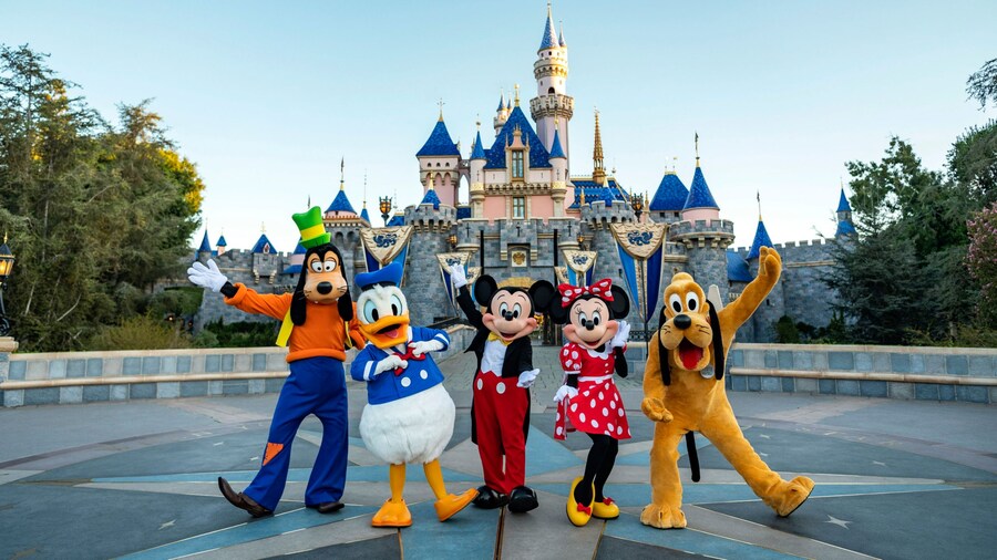 Mickey Mouse, Minnie Mouse, Goofy, Donald Duck and Pluto posing in front of Sleeping Beauty Castle