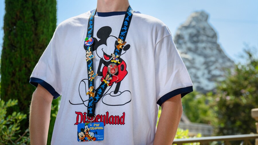 A Guest wearing a Disneyland shirt and a lanyard covered in trading pins