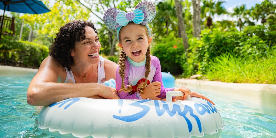 Una madre empuja a su hijo en un flotador por Cross Country Creek, en Disney’s Blizzard Beach Water Park
