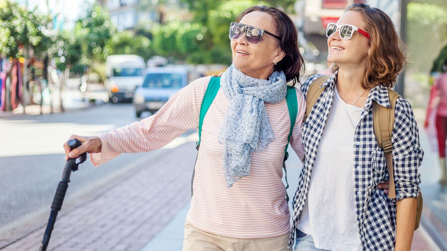 A woman with a cane and a young woman looking up and smiling