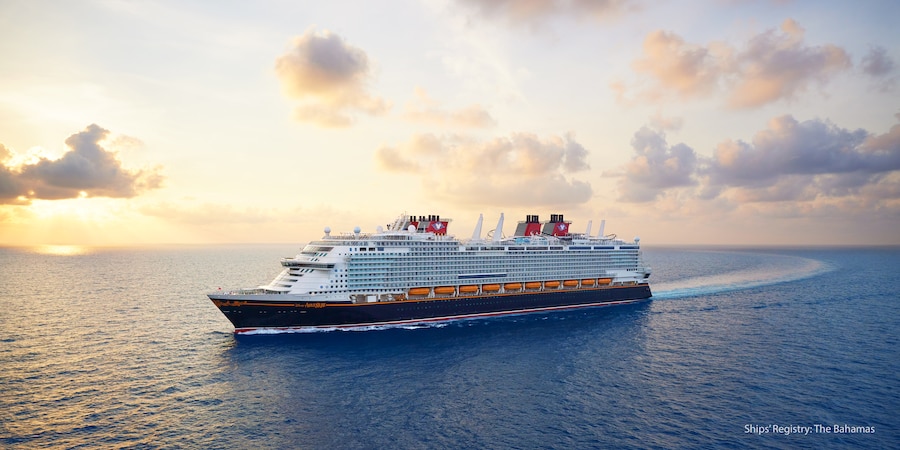 The Disney Adventure cruise ship at sea, with the sun setting in the distance