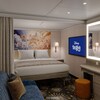 A sofa, 2 pieces of wall art, built in shelving, lighted mirror, privacy curtain, queen size bed and TV