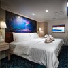 A Standard Inside Stateroom with a queen size bed, closet, 2 nightstands, 2 wall sconces, a TV, wall art, a privacy curtain, pull down bed and sofa bed
