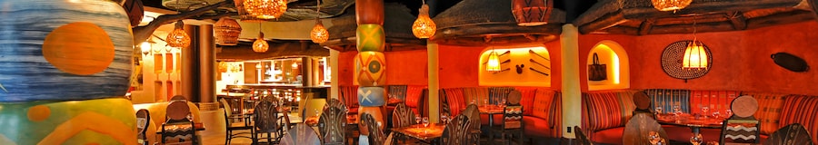 Hanging lanterns over tables with tribal design chairs and wall decore