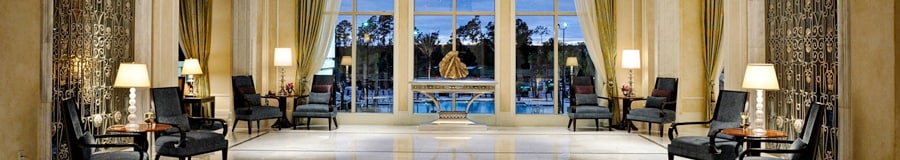 Une mezzanine spacieuse avec des chaises le long des murs et une vue sur la piscine d’un hôtel